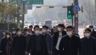 Pedestrians wearing face masks cross a street in Seoul on November 26, 2020. South Korea reported its highest daily number of coronavirus cases since March on November 26, with a surge of new infections sparking fears of a major third wave. / AFP / Ed Jon
