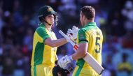 Australia's captain Aaron Finch (R) celebrates reaching his century with teammate Steve Smith during the one-day international cricket match against India at the Sydney Cricket Ground (SCG) in Sydney on November 27, 2020. / AFP / DAVID GRAY /