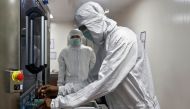 FILE PHOTO: An employee in personal protective equipment (PPE) removes vials of AstraZeneca's COVISHIELD, coronavirus disease (COVID-19) vaccine from a visual inspection machine inside a lab at Serum Institute of India, Pune, India, November 30, 2020. REU