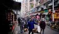 People wearing protective masks walk at a street market almost a year after the start of the coronavirus disease (COVID-19) outbreak, in Wuhan, Hubei province, China December 7, 2020. Picture taken December 7, 2020. REUTERS/Aly Song