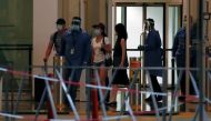 Passengers leave Marina Bay Cruise Center after disembarking from the Royal Caribbean's Quantum of the Seas cruise ship, which is moored after a passenger tested positive for coronavirus disease (COVID-19) during a cruise to nowhere, in Singapore, Decembe