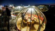 A waiter sets a table inside a transparent pod offered for private Christmas meals with backdrop of the Kremlin and Red Square on the rooftop of Ritz-Carlton hotel in Moscow, Russia December 8, 2020. Picture taken December 8, 2020. REUTERS/Maxim Shemetov 