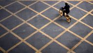 A person wearing a mask rides a bicycle of bike-sharing service on a street, almost a year after the start of the coronavirus disease (COVID-19) outbreak, in Wuhan, Hubei province, China December 17, 2020. REUTERS/Aly Song