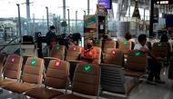A man wearing a face mask as a preventative measure against Covid-19 coronavirus sits in the departure terminal of Suvarnabhumi International Airport in Bangkok on December 18, 2020. / AFP / Jack TAYLOR