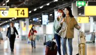 People wearing protective face masks stand, as Schiphol Airport reduces its flights due to the coronavirus disease (COVID-19) outbreak, in Amsterdam, Netherlands April 2, 2020. REUTERS/Piroschka van de Wouw