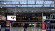 A traveller looks at train departure boards in an almost deserted concourse at Charing Cross train station in London on December 20, 2020. AFP / Niklas HALLE'N