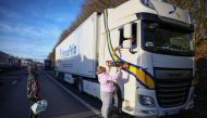 A woman hands out donated food to a lorry driver on the outskirts of Ashford, amid the coronavirus disease (COVID-19) outbreak, December 25, 2020. (REUTERS/Henry Nicholls)