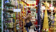 An Iranian woman, wearing a protective face mask, shops at a store selling Christmas decorations in the capital Tehran on December 22, 2020. / AFP / ATTA KENARE