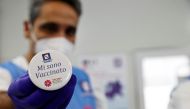 A member of the medical staff shows a pin reading 