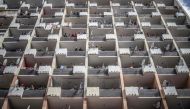Residents of a Hillbrow, Johannesburg, building observe from the balconies on March 28, 2020 as a police operation is conducted to make sure everyone observes the Country's lockdown. AFP / MARCO LONGARI
