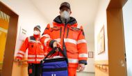 A medical worker carries a box of vials containing the Pfizer-BioNTech COVID-19, coronavirus vaccine during an inoculation program at a care home in Grossraeschen, eastern Germany , on December 27, 2020. / AFP / POOL / FABRIZIO BENSCH