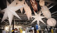 People wearing face masks look at the Christmas decorations while shopping in Moscow on December 28, 2020, amidst the Covid-19 pandemic caused by the novel coronavirus. Russia confirmed 27,787 new daily Covid-19 cases including 6,253 in Moscow. / AFP / Al