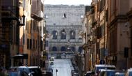 A man crosses a street near the Colosseum on New Year's Day amid the coronavirus disease (COVID-19) outbreak in Rome, Italy January 1, 2021. REUTERS/Guglielmo Mangiapane