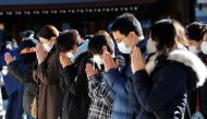 People wearing protective masks amid the coronavirus disease (COVID-19) outbreak, pray on the first day of the new year at the Meiji Shrine in Tokyo, Japan, January 1, 2021. Reuters/Kim Kyung-Hoon