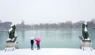 People carry umbrellas during heavy snowfall in Retiro park in Madrid, Spain, January 8, 2021. REUTERS/Juan Medina