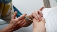 A healthcare worker receives a dose of the Pfizer-BioNTech COVID-19 vaccine at a coronavirus disease vaccination center inside a gymnasium in Taverny near Paris, France, January 9, 2021. REUTERS/Benoit Tessier