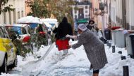 A woman throws water on a snow-covered street, following heavy snowfall, in Madrid, Spain January 11, 2021. REUTERS/Susana Vera/File Photo