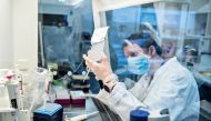 A person uses laboratory equipment as researchers at Aalborg University screen and analyse all the positive Danish coronavirus disease (COVID-19) samples for the new English virus variant 