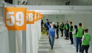 Vaccine center workers stand near cabins being used to inoculate people against the coronavirus disease (COVID-19) on the opening day of a vaccination center at the Messe Berlin trade fair grounds in Berlin, Germany January 18, 2021. Sean Gallup/Pool via 