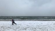 Children run on the beach during a snowfall in Sopot, Poland January 15, 2021. REUTERS/Radu Sigheti