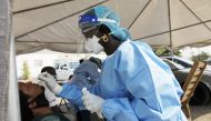 A health worker collects a nose swab from a man at a drive-through sample collection centre for coronavirus disease (COVID-19) in Abuja, Nigeria January 14, 2021. REUTERS/Afolabi Sotunde

