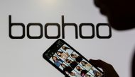 File photo: A woman poses with a smartphone showing the Boohoo app in front of the Boohoo logo in this illustration taken September 30, 2020. Reuters/Dado Ruvic/Illustration/File Photo