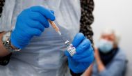 FILE PHOTO: A health worker fills a syringe with a dose of the Oxford/AstraZeneca COVID-19 vaccine at the Appleton Village Pharmacy, amid the coronavirus disease (COVID-19) outbreak, in Widnes, Britain January 14, 2021. REUTERS/Jason Cairnduff