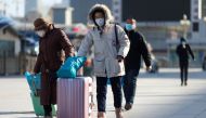 Travelers wearing face masks following the coronavirus disease (Covid-19) outbreak walk outside a railway station as the Spring Festival travel season begins ahead of the Chinese Lunar New Year, in Beijing, China January 28, 2021. Reuters/Carlos Garcia Ra