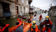 Rescue workers on small boats help residents in a flooded area as the Charente River overflows in Saintes after days of rainy weather causing flooding in western France, France, February 8, 2021. REUTERS/Stephane Mahe