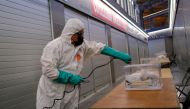 A worker uses disinfectant to clean ballot boxes containing personal protective equipment (PPE) supplies at Sant Antoni Market, which will be a polling station for the February 14th regional election, during the coronavirus disease (COVID-19) outbreak in 