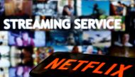 FILE PHOTO: A smartphone with the Netflix logo lies in front of displayed 