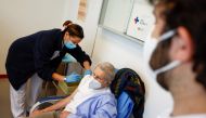 A man receives a dose of the Pfizer-BioNTech vaccine during the coronavirus disease (COVID-19) vaccination campaign, as the country sees a surge in the number of infections, in Rome, Italy, March 4, 2021. REUTERS/Guglielmo Mangiapane
