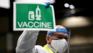 Doctor John Thayer holds up a sign to signal his station needs more vaccine doses as people attend a coronavirus disease (COVID-19) vaccination site at Lumen Field Event Center in Seattle, Washington, U.S. March 13, 2021. Reuters/Lindsey Wasson