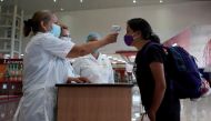 FILE PHOTO: A traveller has her temperature checked at the Jose Marti International Airport amid concerns about the spread of the coronavirus disease (COVID-19), in Havana, Cuba, November 15, 2020. REUTERS/Alexandre Meneghini/File Photo
