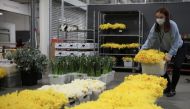 Cassie Burt, marketing and communications manager of Covent Garden Market Authority, prepares flowers during the day of reflection to mark the anniversary of Britain's first coronavirus disease (COVID-19) lockdown, at the New Coven Garden Flower Market in