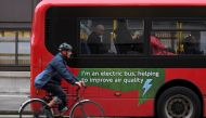 A cyclist rides past an electric public bus on the day that Mayor of London Sadiq Khan outlined plans to place a levy on the most polluting vehicles in London, Britain, April 4, 2017. REUTERS/Toby Melville/File Photo