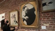 An art handler shows to reporters work 