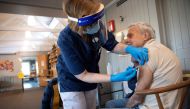 FILE PHOTO: A health worker vaccinates an elderly person with Pfizer's COVID-19 vaccine at a temporary vaccination clinic in a church in Sollentuna, north of Stockholm, Sweden March 2, 2021. Fredrik Sandberg/TT News Agency/via REUTERS
