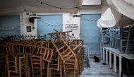  A cat is seen next to piled up chairs in front of a closed restaurant in Thissio district, following the coronavirus disease (COVID-19) outbreak, in Athens, Greece, April 28, 2020. Picture taken April 28, 2020. REUTERS/Alkis Konstantinidis/File Photo/Fil