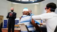U.S. President Joe Biden applauds a man as he receives a vaccine at the coronavirus disease (COVID-19) vaccination site at Virginia Theological Seminary in Alexandria, Virginia, U.S., April 6, 2021. REUTERS/Kevin Lamarque
