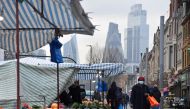 People shop at market stalls, with skyscrapers of the CIty of London financial district seen behind, amid the coronavirus disease (COVID-19) pandemic, in London, Britain, January 15, 2021. REUTERS/Toby Melville