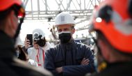 French President Emmanuel Macron talks with workers during a visit at the reconstruction site of the roof of the Notre-Dame de Paris Cathedral, which was damaged in a devastating fire two years ago, as restoration works continue, in Paris, France, April 1