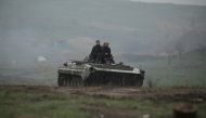 Service members of the Ukrainian armed forces drive an armoured vehicle during a training at a firing range in Donetsk region, Ukraine April 20, 2021. REUTERS/Serhiy Takhmazov