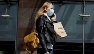  A woman wearing a protective mask walks in front of the Zlote Tarasy shopping mall in the centre of the city as the government eased coronavirus disease (COVID-19) restrictions, in Warsaw, Poland May 4, 2021. REUTERS/Kacper Pempel/File Photo
