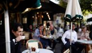 A customer enjoys a drink at the terrace of the cafe and restaurant Les Deux Magots, as cafes, bars and restaurants reopen their terraces after closing down for months, amid the coronavirus disease (COVID-19) outbreak, in Paris, France, May 19, 2021. Reut