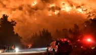 Flames rise as firefighters and volunteers try to extinguish a fire burning in the village of Schinos, near Corinth, Greece, May 19, 2021. Picture taken May 19, 2021. REUTERS/Vassilis Psomas