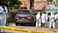 Forensic experts secure the scene of an attempted assassination on Ugandan minister of works and transport General Katumba Wamala, in which he was wounded and his daughter and driver killed, an army spokeswoman and local media reports said, in the suburb 