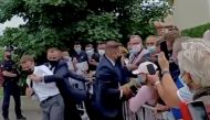 French President Emmanuel Macron is protected by a security member after getting slapped by a member of the public during a visit in Tain-L'Hermitage, France, in this still image taken from video on June 8, 2021. (BFMTV/ReutersTV)