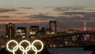 A general view of the Olympic Rings installed on a floating platform with the Rainbow Bridge in the background in preparation for the Tokyo 2020 Olympic Games in Tokyo, Japan June 21, 2021. Picture taken with long exposure. REUTERS/Pawel Kopczynski
