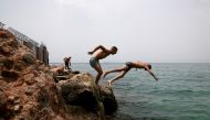People dive into the sea from a rock during a heatwave in Alimos suburb, south of Athens, Greece July 1, 2021. REUTERS/Costas Baltas